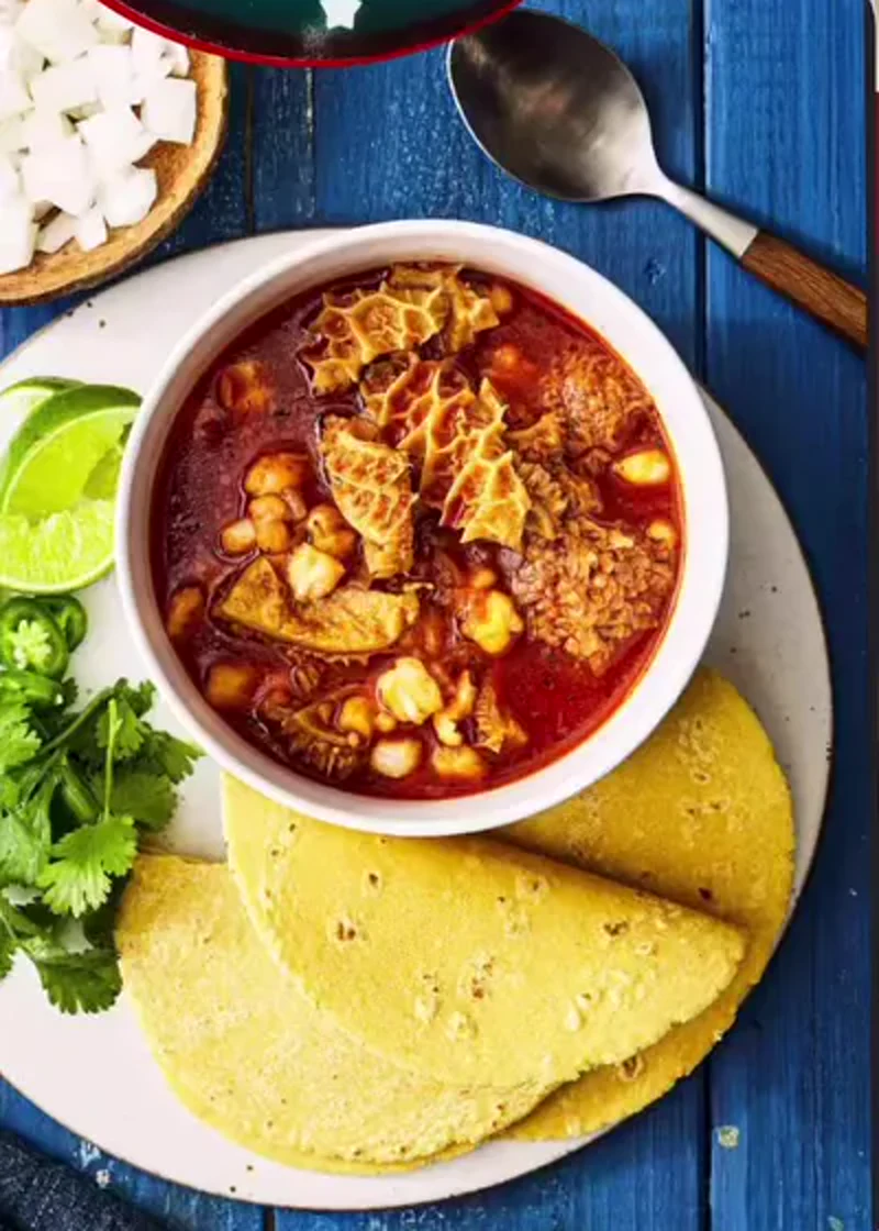 A bowl of menudo with tortillas shown in an Antojitos del Gordo social graphic